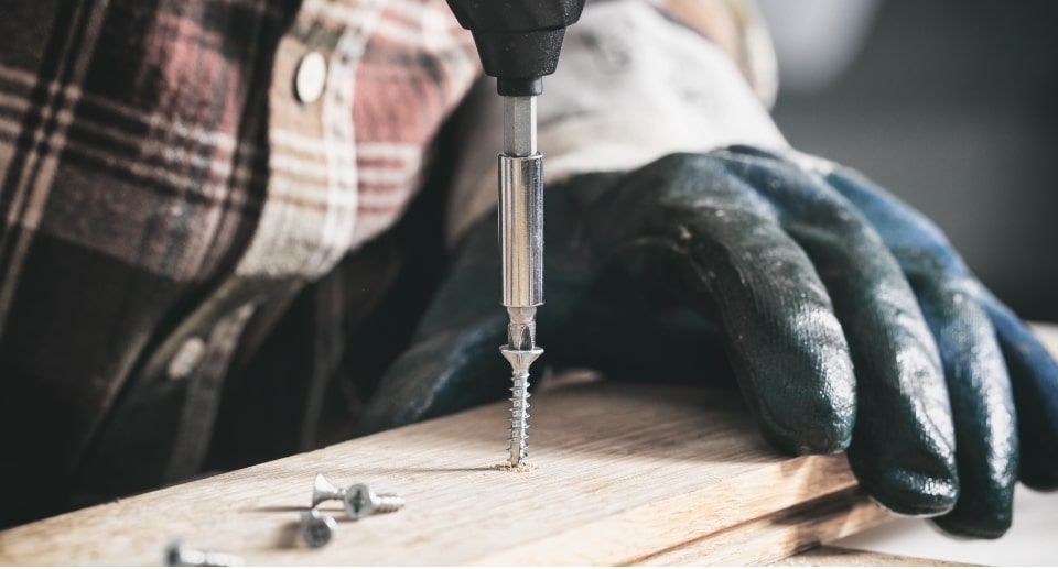 A person drilling a Pro-Twist screw in wood