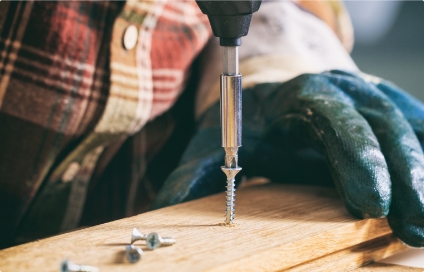A construction worker drilling a Pro-Twist screw into wood