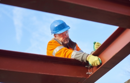 A construction worker doing work on a frame of a roof