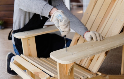 A person screwdriving screws into a chair